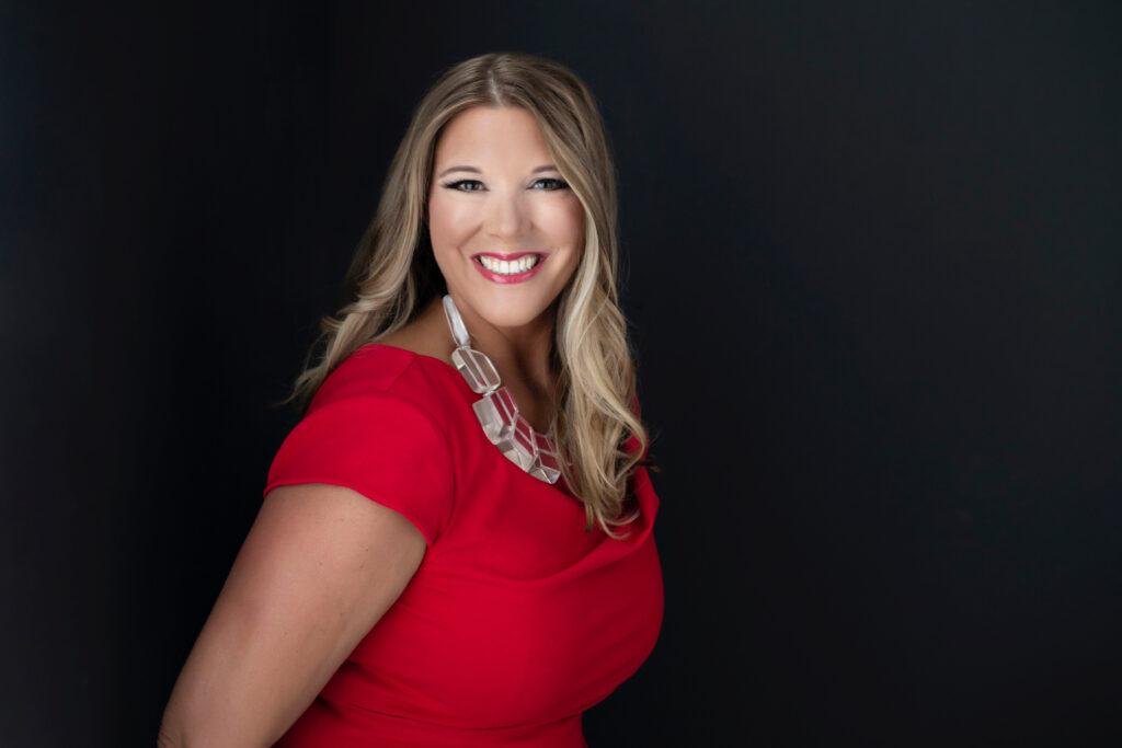 photo of Jodi in a red top on a black background